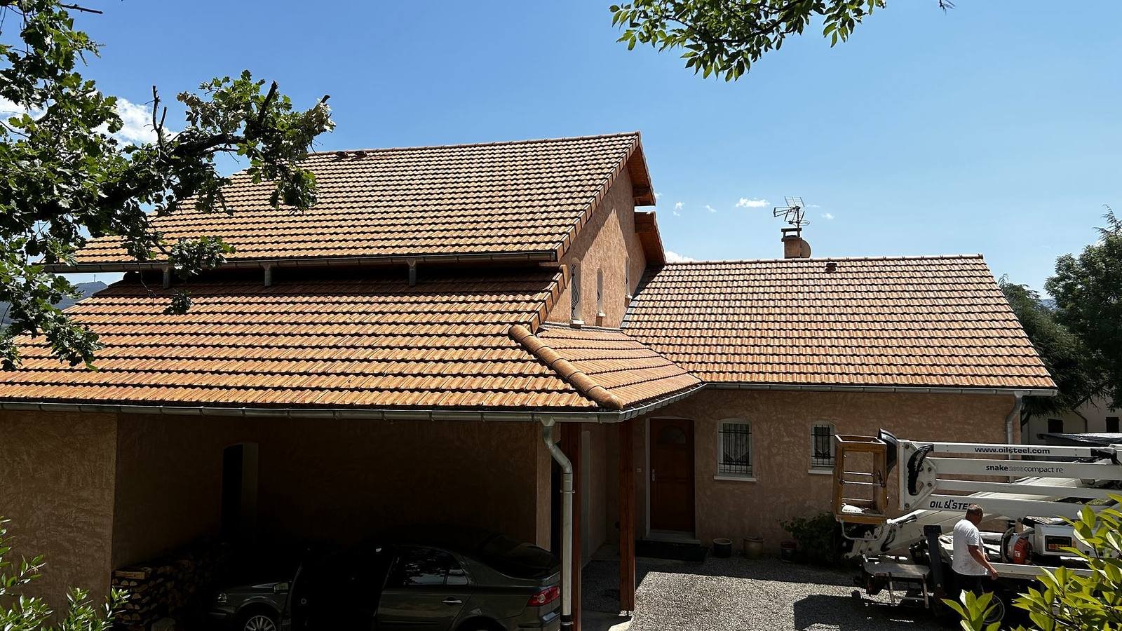 Maison à toiture en tuiles avec un camion nacelle garé sur le côté