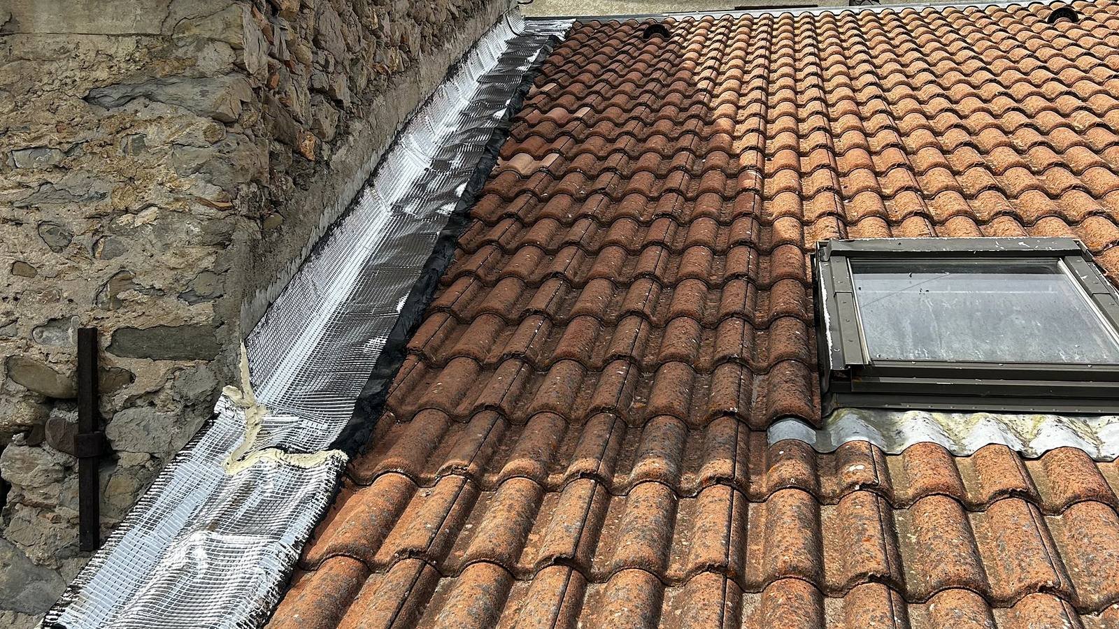 Solin en zinc et fenêtre de toit sur une toiture en tuiles